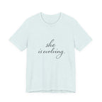 She Is Evolving Tee — Feminine Script Inspirational T-Shirt