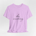 She Is Evolving Tee — Feminine Script Inspirational T-Shirt