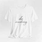 She Is Evolving Tee — Feminine Script Inspirational T-Shirt