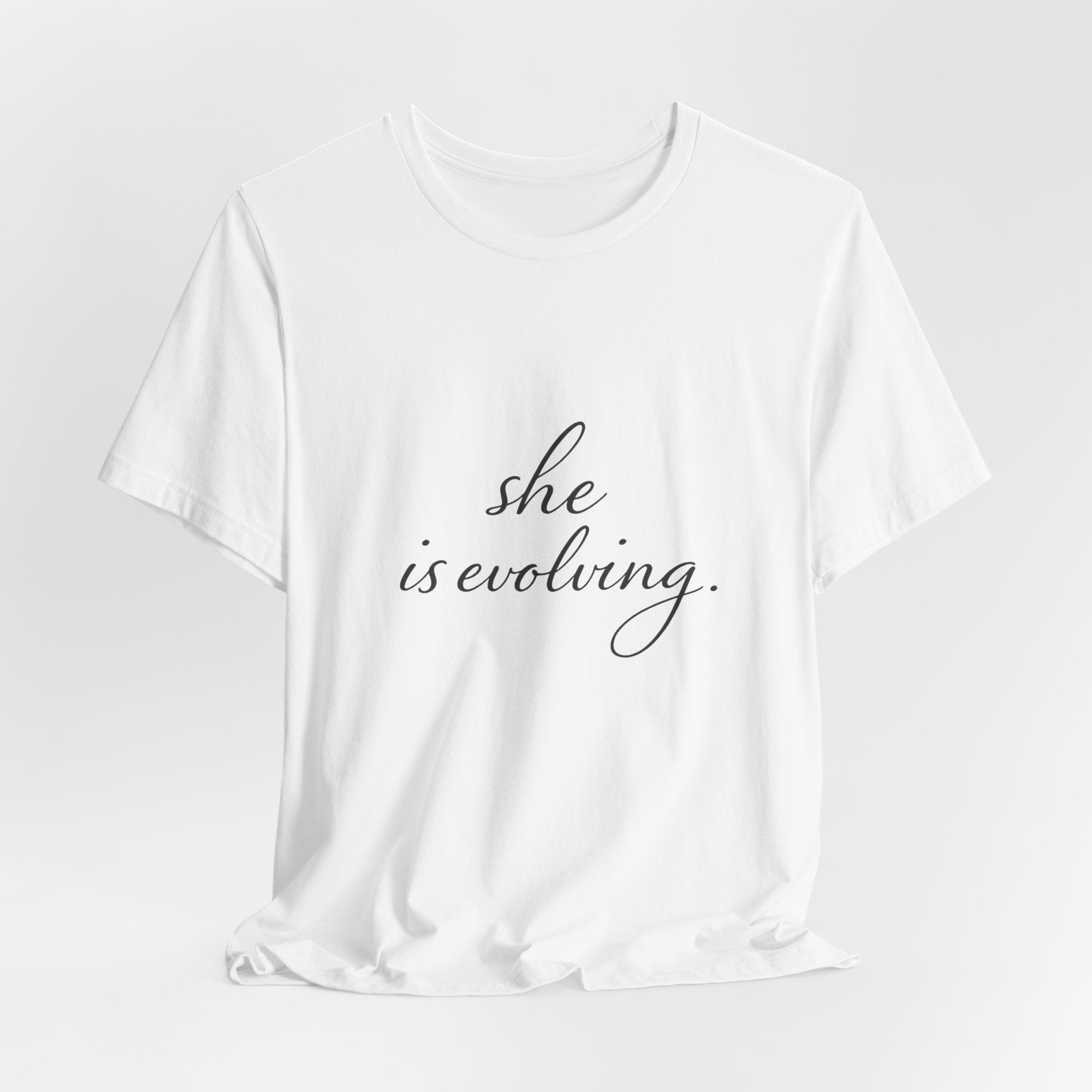 She Is Evolving Tee — Feminine Script Inspirational T-Shirt