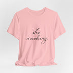 She Is Evolving Tee — Feminine Script Inspirational T-Shirt