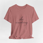 She Is Evolving Tee — Feminine Script Inspirational T-Shirt