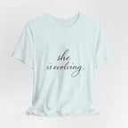 She Is Evolving Tee — Feminine Script Inspirational T-Shirt