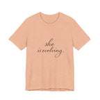 She Is Evolving Tee — Feminine Script Inspirational T-Shirt
