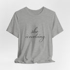 She Is Evolving Tee — Feminine Script Inspirational T-Shirt