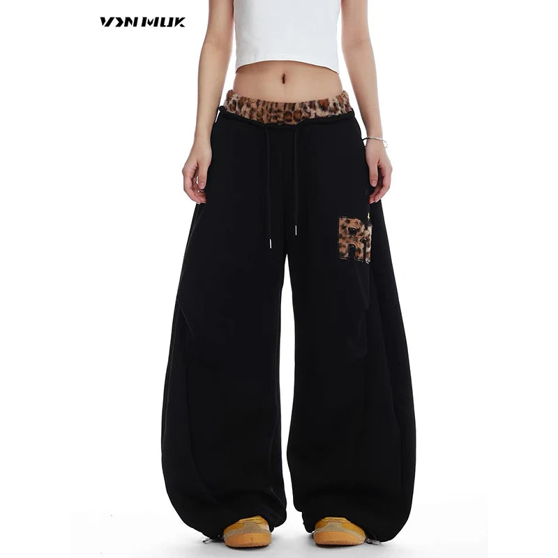Black baggy pants with leopard print details on a white background - Winstar Marketing