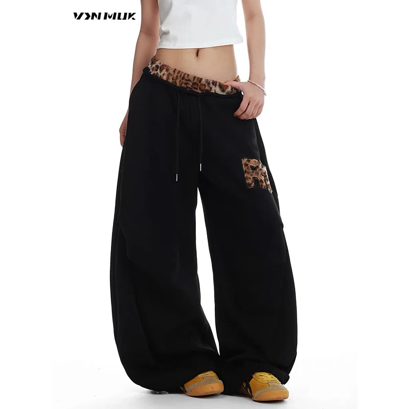 Black baggy pants with leopard print details on a white background - Winstar Marketing